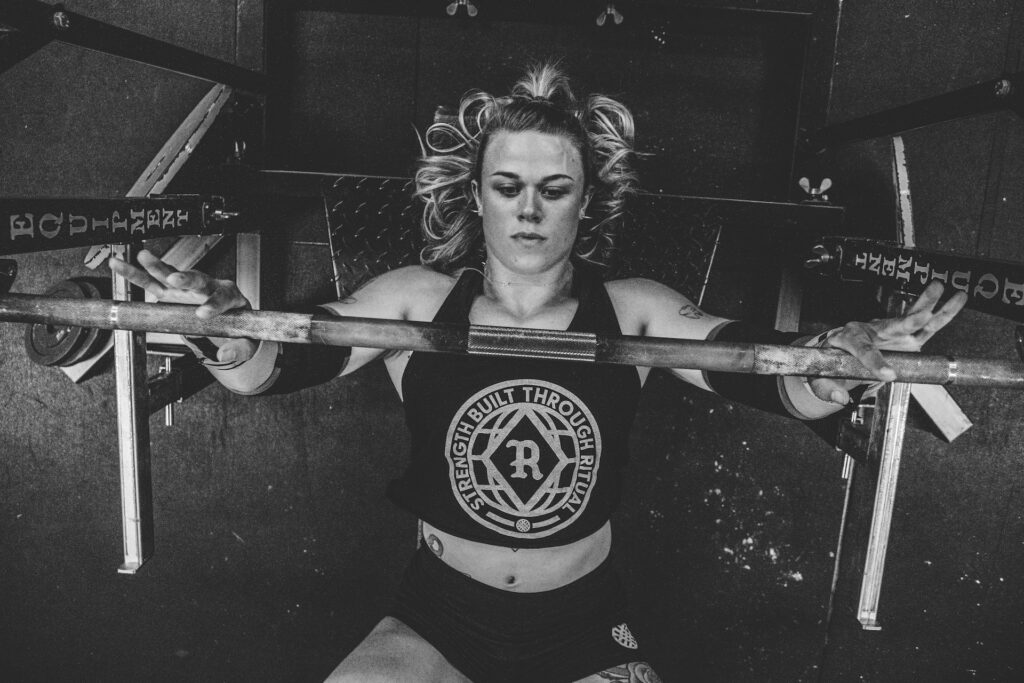 A woman at the gym showing her exercise set up for a horizontal pressing movement, in this case a benchpress