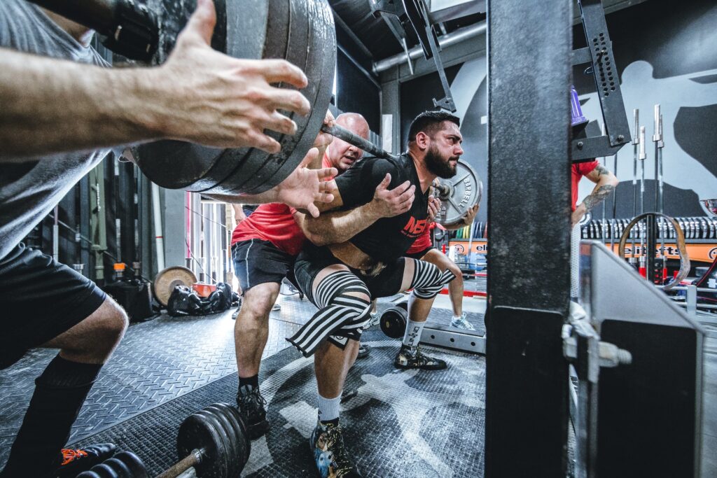 The lifter is performing a squat which is a high fatigue exercise