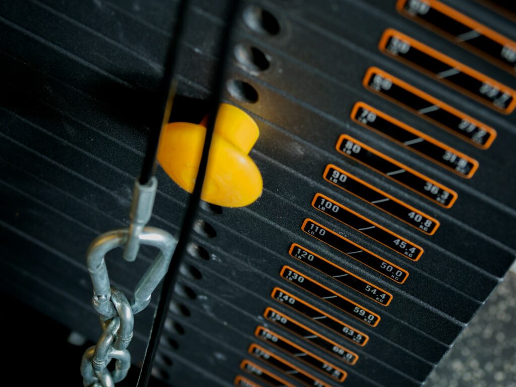 Exercise machine with selector pin placed into the weight stack for a warm up set