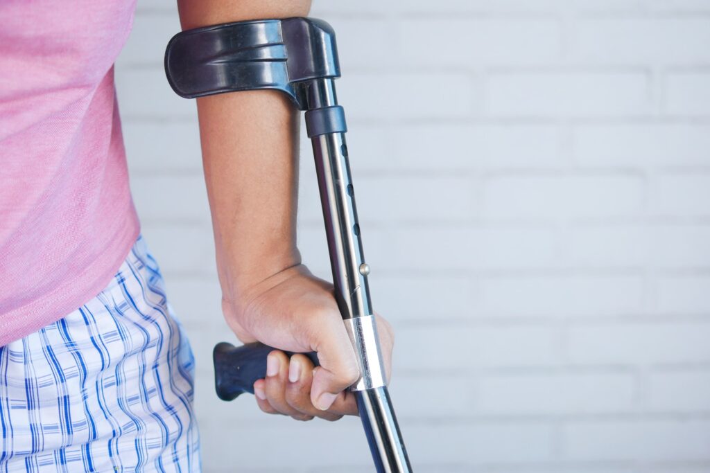 Person with an injury uses a crutch